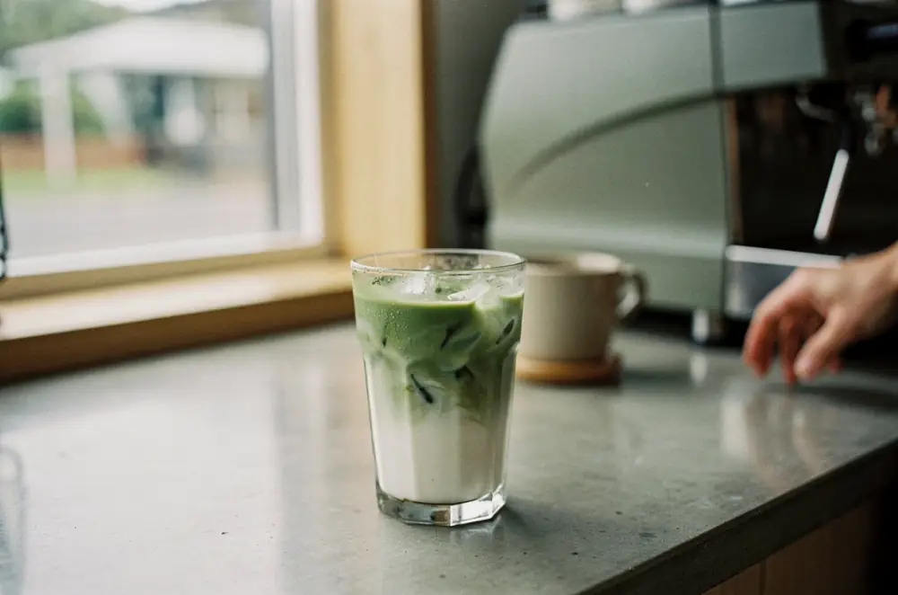 An iced matcha latte on a concrete cafe counter
